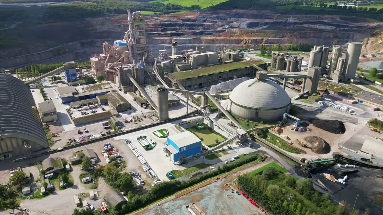 A drone panning shot shows the cement factory in Saint-Pierre-la-Cour, with its large industrial structures and the quarry visible in the background