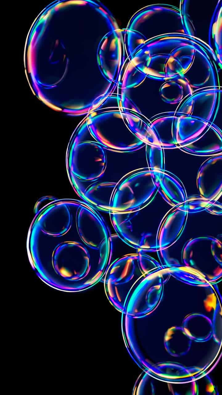 Close-up video of colorful soap bubbles against a black background, capturing their iridescent hues