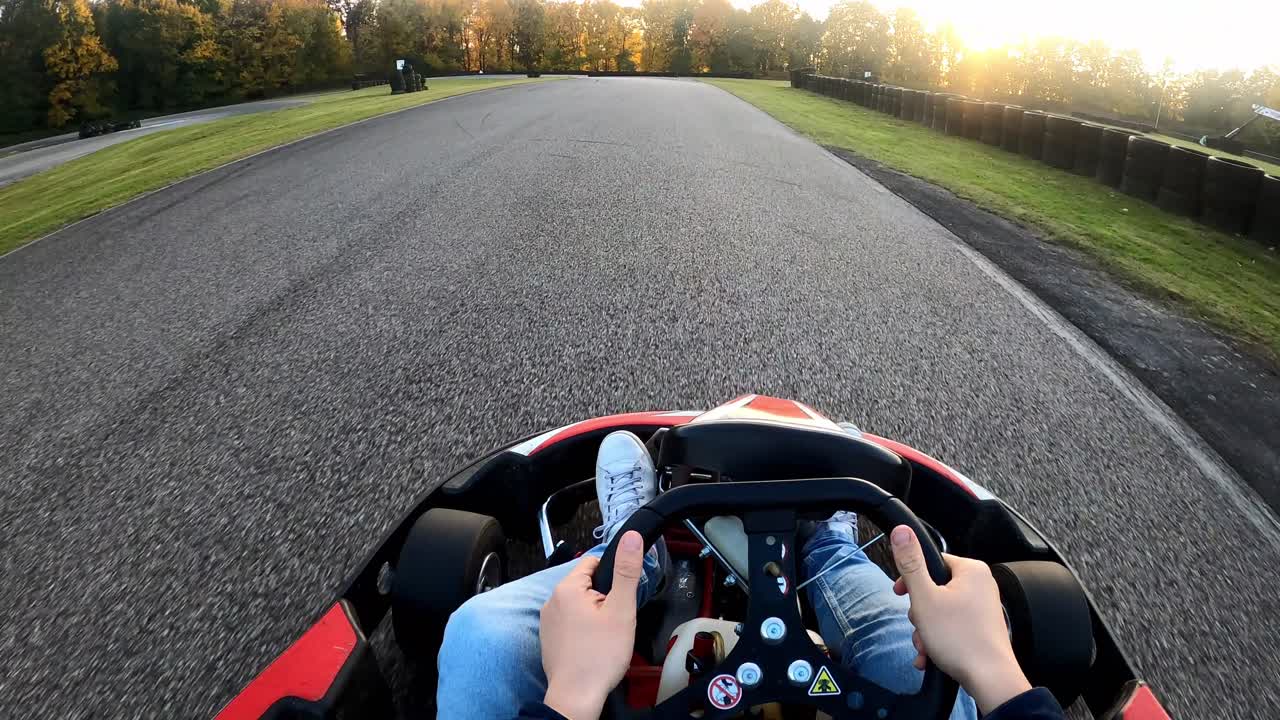 Kjører gokart på racerbane ved solnedgang, sett fra førersetet