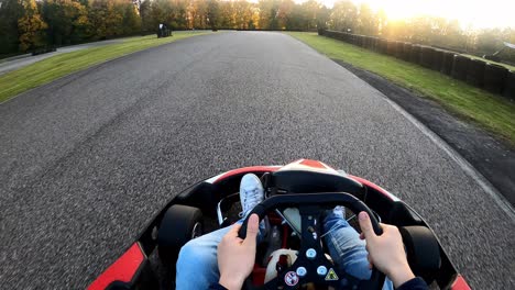 riding a go kart at sunset point of view on race track