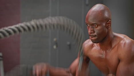 hombre usando cuerdas de batalla en el gimnasio de crossfit