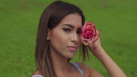 close up of a young girl holding a flower to her face at the park