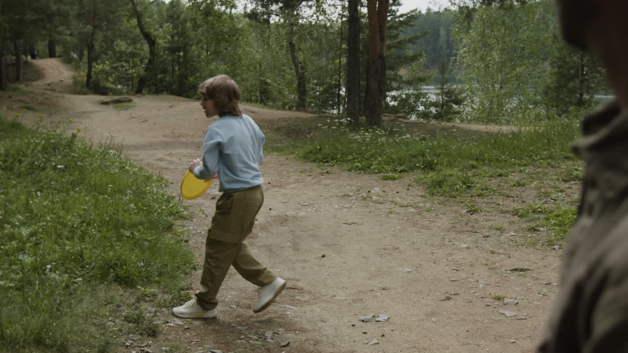 Father and Son Playing Frisbee in the Woods