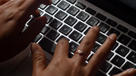 a tight angle of an asian woman typing on a computer laptop keyboard