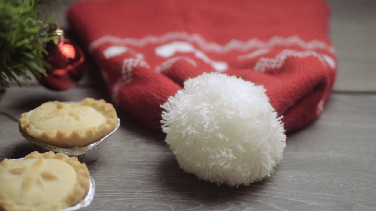 mano agarrando pastel de carne picada en el fondo de navidad