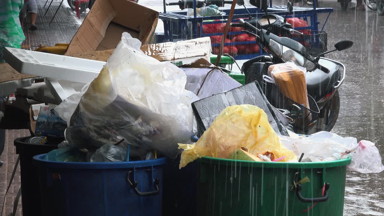 비 오는 날 쓰레기로 가득 찬 쓰레기통