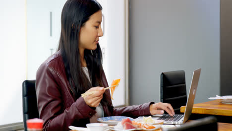 woman having sushi while using laptop in restaurant 4k