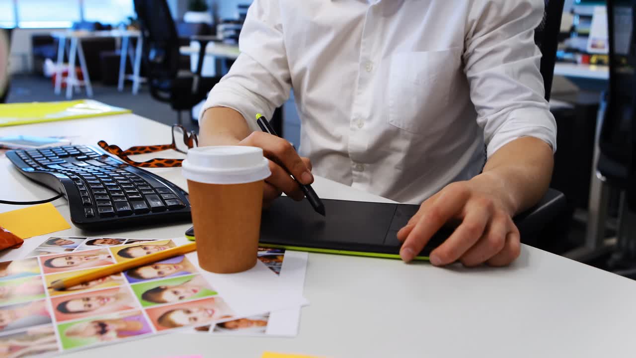 diseñador gráfico masculino trabajando en una tableta gráfica en el escritorio