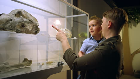 little boy in his mother's arms in a natural history museum, medium shot