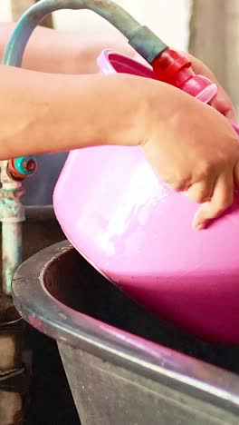 person washing with pink basin in bangkok