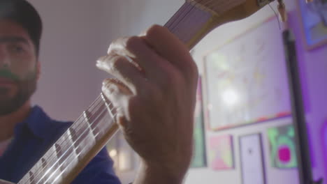 creative man playing the guitar in art studio