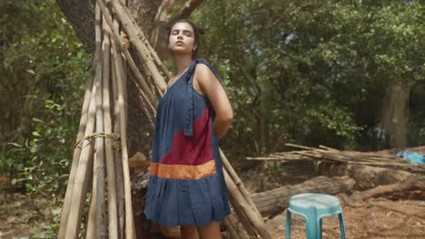 Imagen-Cinematográfica-En-Cámara-Lenta-De-Una-Modelo-India-Con-Un-Vestido-De-Moda-Sostenible-Azul,-Rojo-Y-Naranja-En-El-Bosque-De-Goa,-India,-Slomo