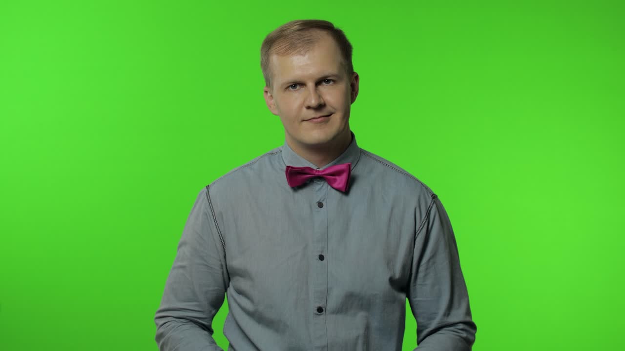 Mand viser ok-tegn, smiler med optimistisk tilfreds udtryk, blinker, okay-tegn på godkendelse