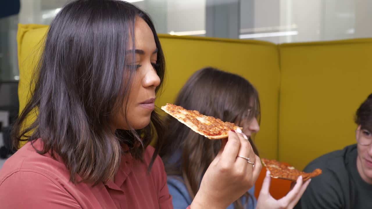 Women enjoying pizza during office break