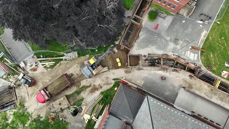 autonomous construction robot compacting dirt on construction site. aerial top down landing shot. modern construction site in housing area of town.