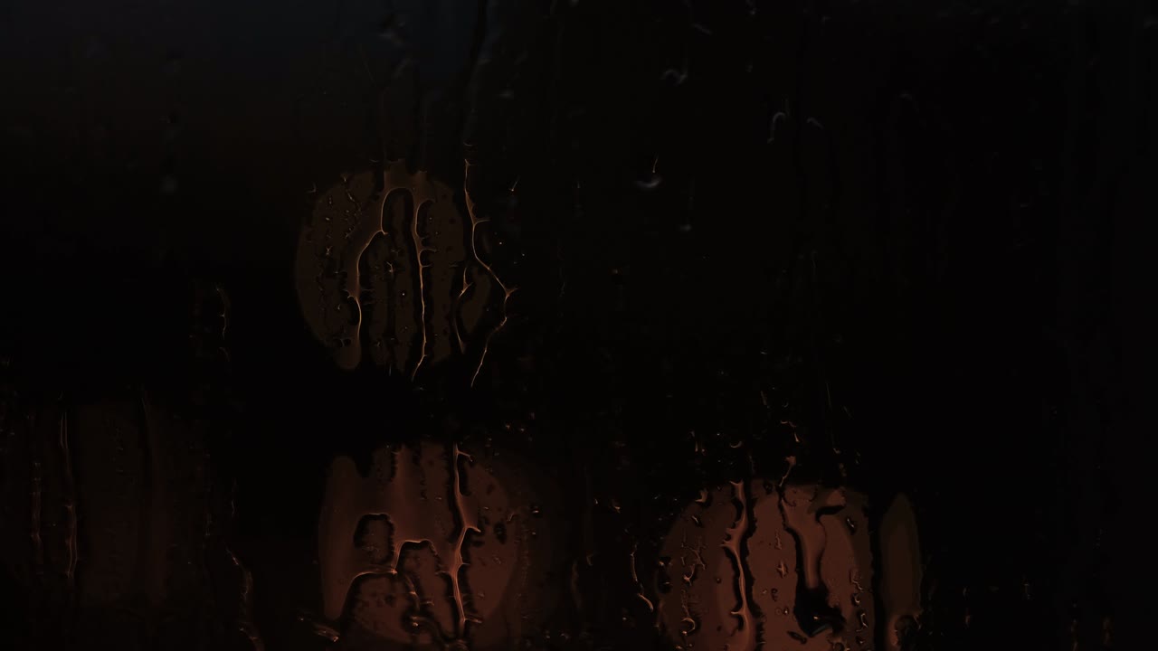 primer plano de gotas en fondo de vidrio de luces bokeh. concepto. a través de la ventana con gotas de lluvia se pueden ver luces borrosas en la oscuridad
