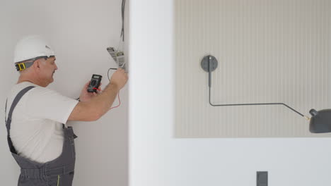 a male electrician installs transformers for illumination in a smart home system. installation lighting