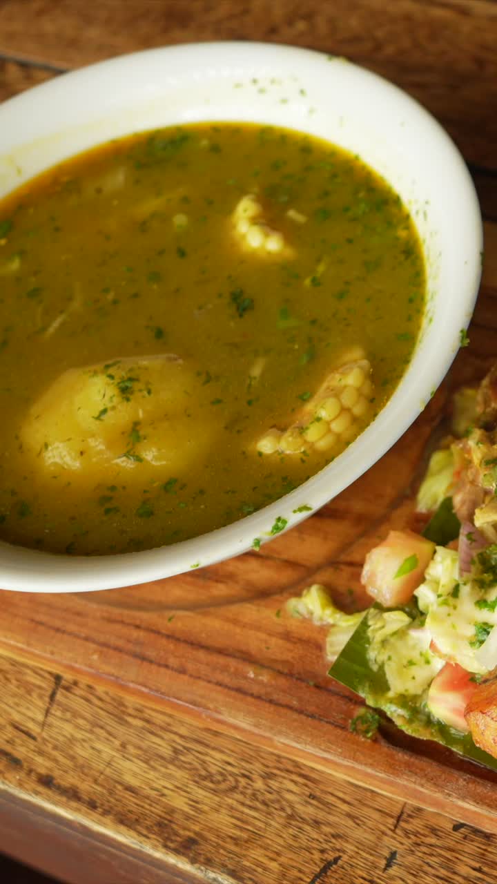 Colombian Sancocho Soup Served with Chicken, Rice, Salad and Avocado Vertical