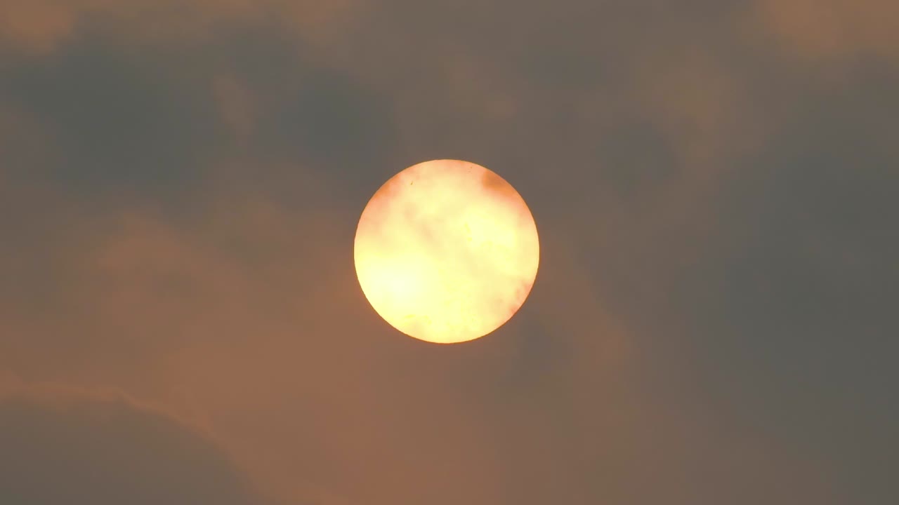 las nubes pasan sobre una brillante luna llena de amarillo por la noche