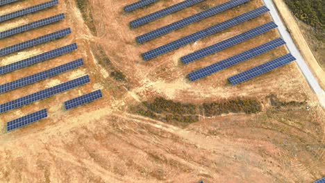 aerial-view-of-solar-farm-over-dry-land,-portugal,-4k