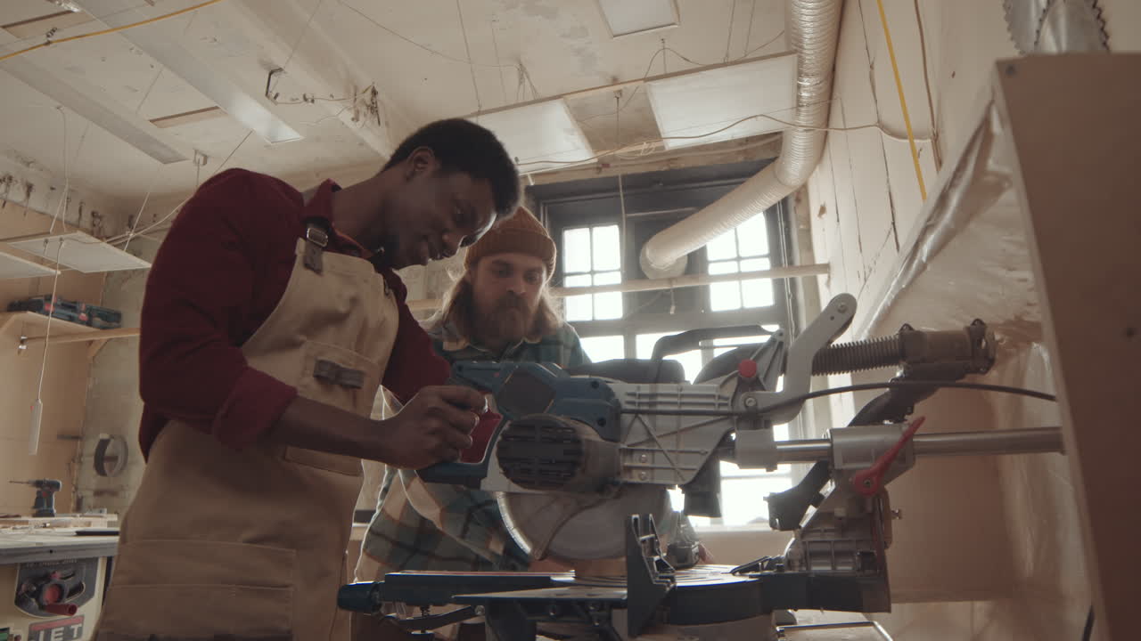 Professional Joiner Watching African American Man Using Circular Saw