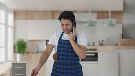 Cocinero-Indio-Enojado-Haciendo-Comida-Mientras-Grita-Por-Teléfono