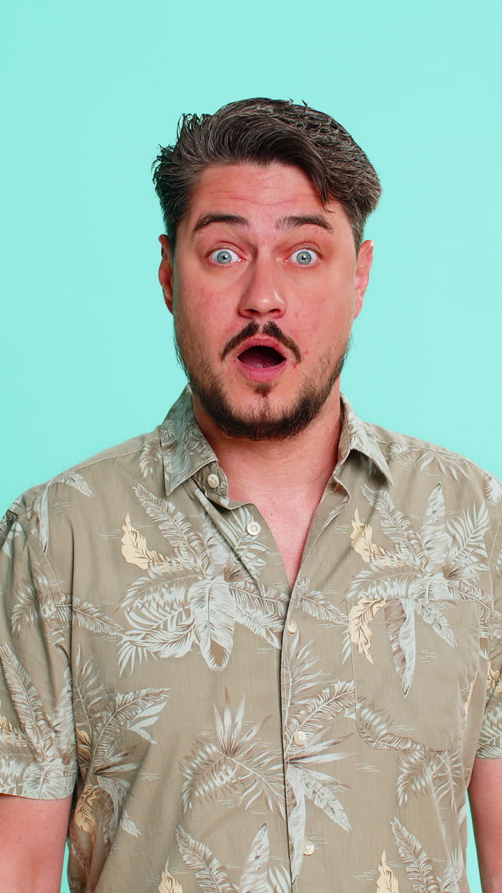 Adult man raising eyebrows opening mouth widening eyes in sudden surprise shock with extreme emotion