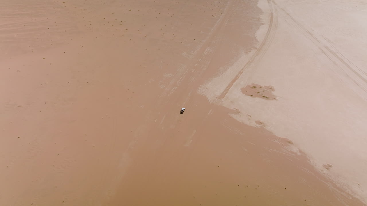 요르단의 와디 럼 사막을 가로지르는 4x4 차량이 있는 황량한 풍경