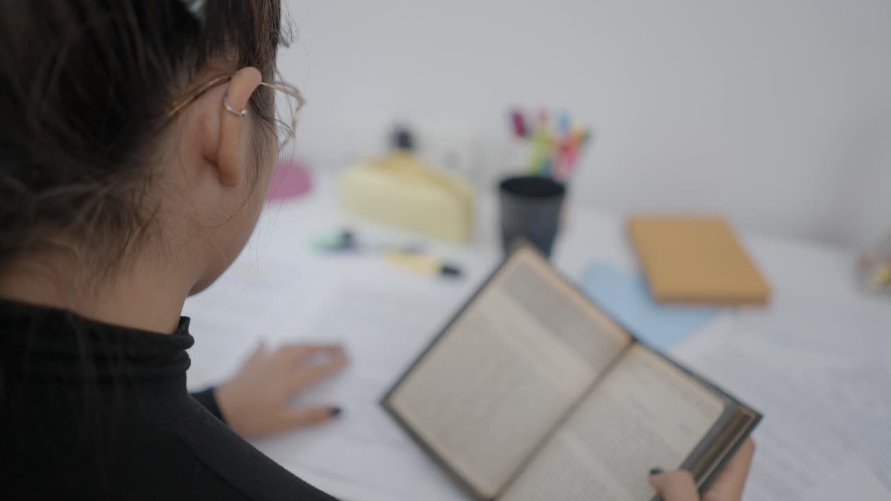 Woman Reading a Book at a Desk