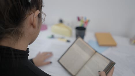 mujer leyendo un libro en un escritorio