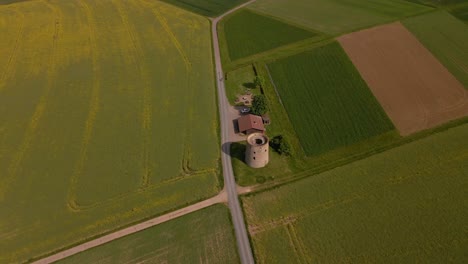 descending tracking shot with pan up of a motorbike driving past the grueninger warte in the german countryside