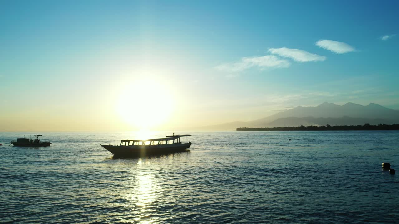 Small fishing boats in the calm water as the sun sets in the exotic, remote area of Seychelles