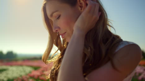 Retrato-De-Una-Hermosa-Mujer-Arreglando-El-Cabello-A-La-Luz-Del-Sol.-Mujer-Relajada-En-El-Jardín