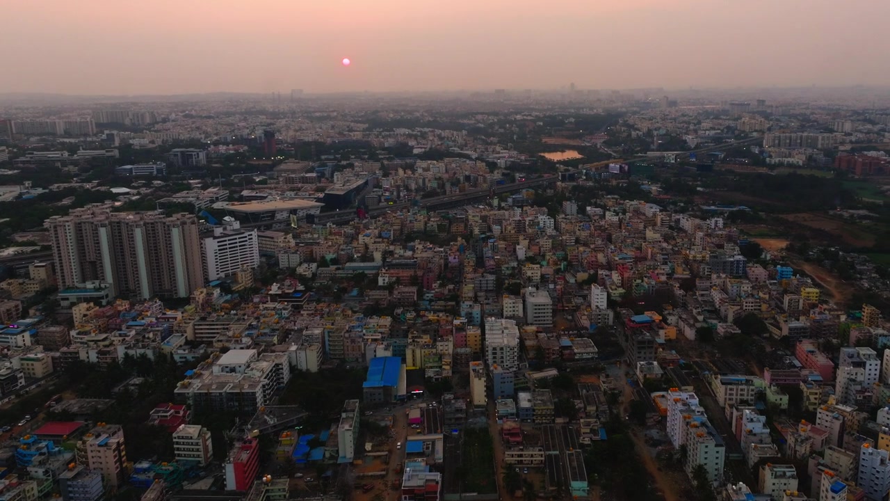 Pemandangan udara Kota Silikon dengan kota elektronik, bangunan perumahan, apartemen, gedung perkantoran, dan matahari di Bangalore, Karnataka, India. Siang hari, rekaman drone yang mendekat, 4K.