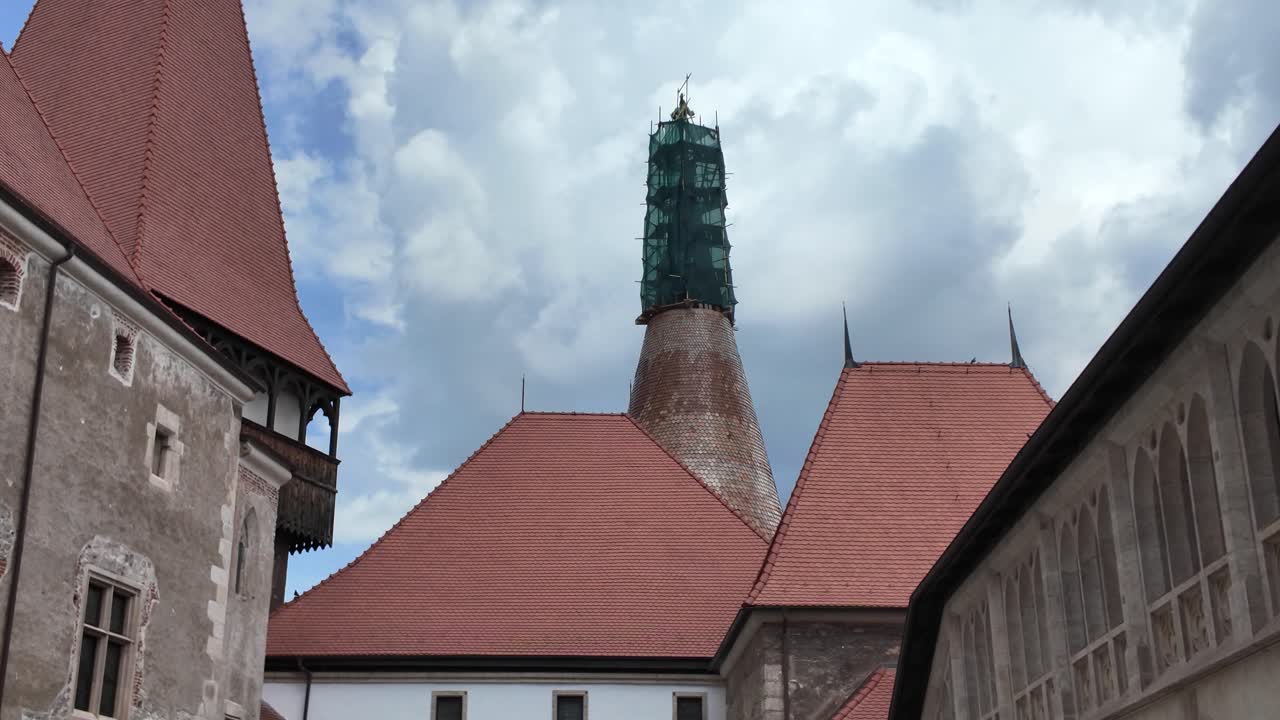 Corvin Castle’s inner courtyard, showing the medieval stone walls, Gothic tower, and historic architectural details