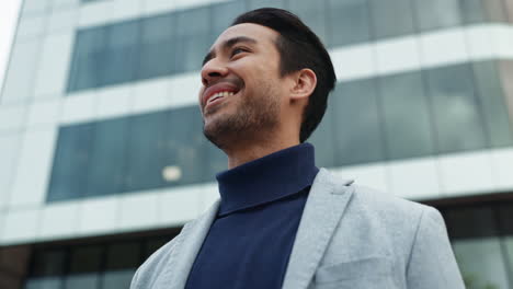 a man in a suit looking up with a positive expression.