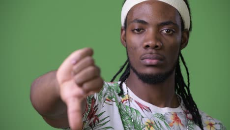 young handsome african man with dreadlocks against green background