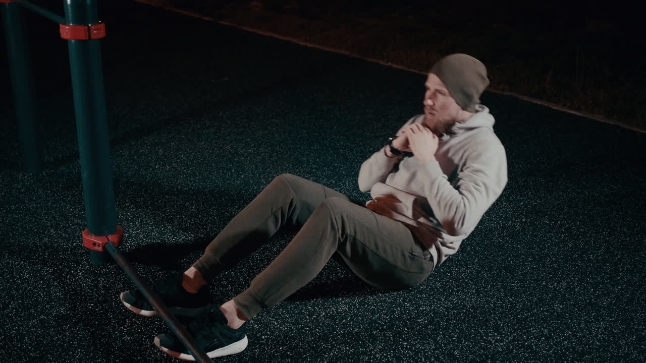 hombre haciendo abdominales nocturnos en un parque