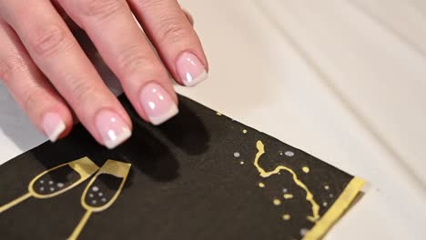 woman tilts her freshly done french manicure finger nails to admire them