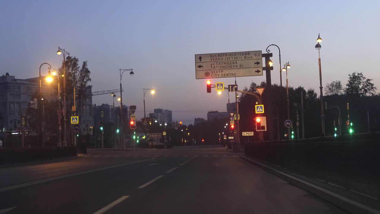 calle de la ciudad vacía al amanecer con semáforos y señales