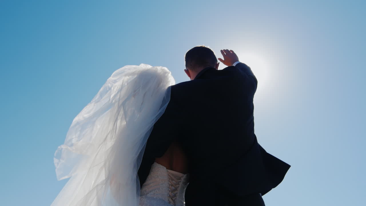 그의 손으로 태양을 닫고 올려다 보는 신부와 신랑