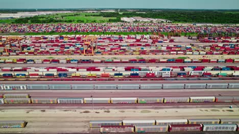 un vibrante mosaico de contenedores marítimos y vagones ferroviarios, una inmensa escala de operaciones modernas de transporte de mercancías intermodal
