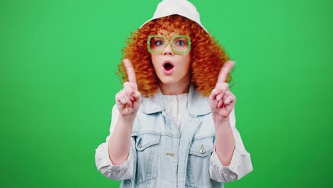 young redhead woman wearing eyeglasses and panama hat shaking head in rejection and shaking fingers to camera, saying no