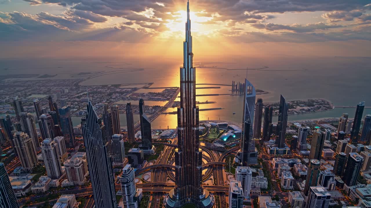 Glistening downtown Dubai skyline reflecting golden hues of sunset over the Persian Gulf, showcasing iconic skyscrapers and striking modern architecture amidst the vibrant dusk