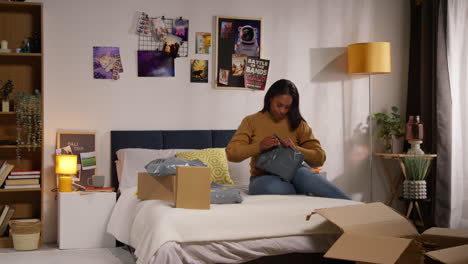 woman unboxing clothes at home