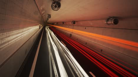 time stop showing colorful light trails left by multiple fast cars in the underground tunnel covered with white glossy tiles. night slow shutter speed illustration. time freeze and camera pitch.