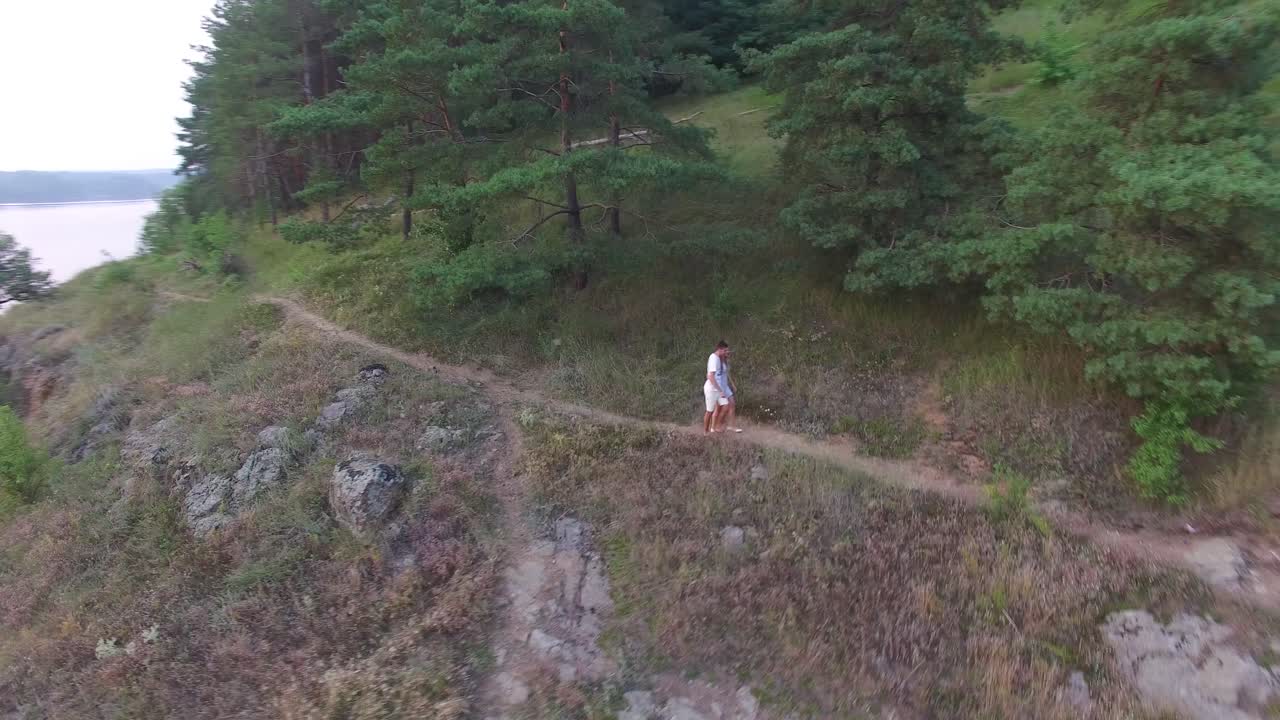 Romantic Couple Enjoying Outdoors. Aerial shot of a handsome guy and beautiful girl resting in river