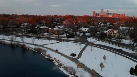 Minneapolis-downtown-in-the-background-lighted-up-by-the-last-moments-of-sun-light,-aerial-view