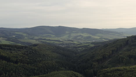 slow forward aerial of green forested hills in rural central europe