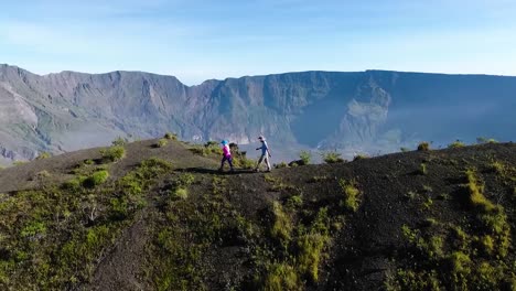 aerial-view-couple-of-trekkers-hiking-the-path-of-Samota-Bridge,-Sumbawa,-Indonesia-during-a-day-of-summer-with-beautiful-mountain-landscape,-epic-travel-destination-for-wild-nature-holiday